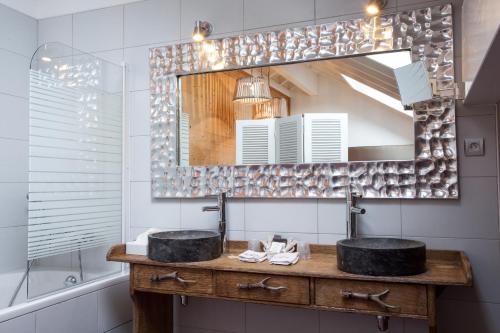 a bathroom with two sinks and a mirror at Auberge De Maison Rouge in Vétraz-Monthoux