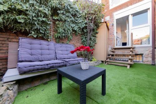 a purple couch sitting on a patio with a table at Apartamento con jardín privado in Coslada
