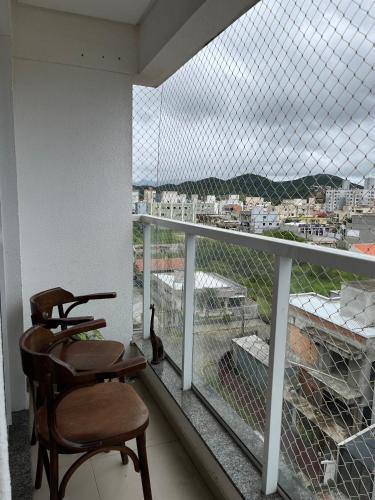 a chair sitting on a balcony with a view at Residencial Lunit in Camboriú