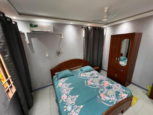 a bedroom with a bed with a green comforter at Elira 2 chambres rez-de-chaussée in Kinshasa