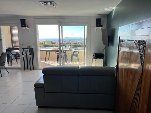 un salon avec un canapé et une table avec des chaises dans l'établissement Sète vue mer, secteur des plages, T3 de standing climatisé avec grande terrasse, à Sète