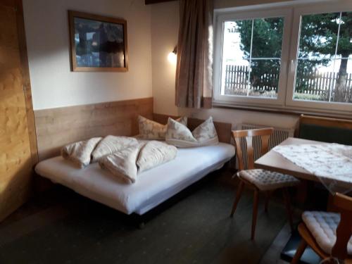 a bed in a room with a table and a window at Petter 1 in Tobadill