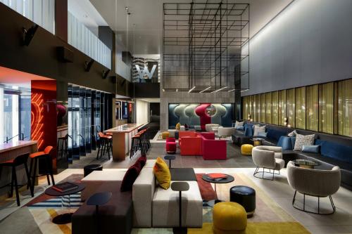 a lobby with couches and chairs and a bar at W Montreal in Montréal
