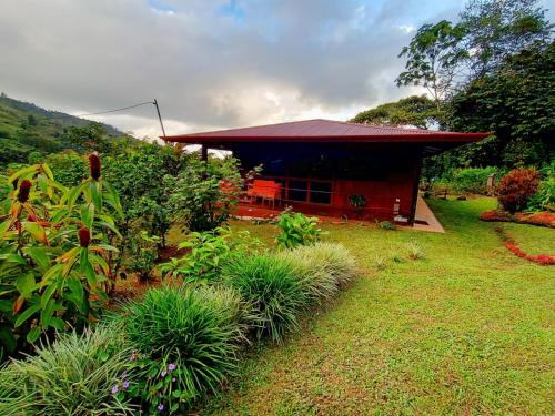 a small house with a red roof in a yard at Aloha chirripo cabaña familiar in Convento