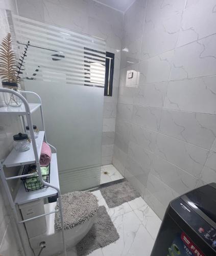 a white bathroom with a shower and a toilet at Fantasy home in Al Aqālitah