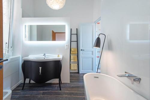 La salle de bains est pourvue d'une baignoire et d'un lavabo noir et blanc. dans l'établissement Riviera Palace Panoramic Sea View 2 Bed Belle Epoch Montecarlo, à Beausoleil