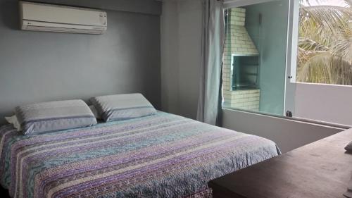 Cama en habitación con ventana y cama sidx sidx sidx sidx en Casa temporada, en Ilhabela