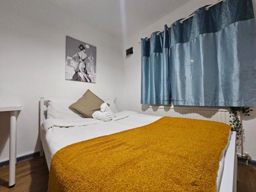 a bedroom with a bed with a yellow blanket at London E14 Stay in London