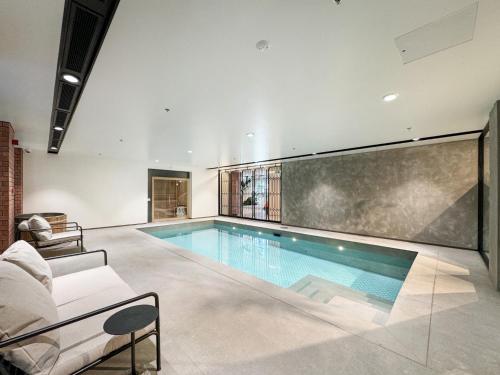 a large swimming pool in a living room with a couch at Brand New Apartment CBD High Rise With Ocean View on the Doorstep of Courtenay Place in Wellington