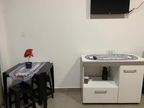 a kitchen with a table and a table with stools at Casa Rebello - Pousada in Itajaí