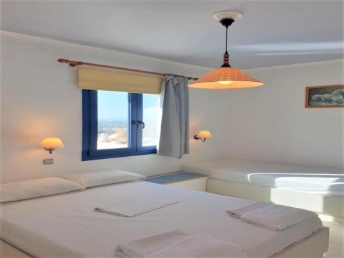 a bedroom with two beds and a window at Hermes Korifi Suites private apartment in Hersonissos