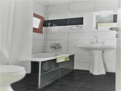 a white bathroom with a sink and a toilet at Hermes Korifi Suites private apartment in Hersonissos