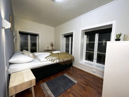 Un dormitorio con una cama y dos ventanas. en Stavanger Bnb - billiard Sauna, en Stavanger