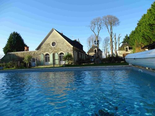 une maison avec une piscine devant une maison dans l'établissement Maison de Charme avec Piscine Chauffée, Proche Châteauroux, Dans une Propriété du 18ème Siècle - FR-1-591-151, à Saint-Maur