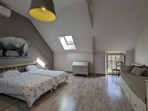 une chambre avec deux lits et un canapé dans l'établissement Maison de Charme avec Piscine Chauffée, Proche Châteauroux, Dans une Propriété du 18ème Siècle - FR-1-591-151, à Saint-Maur