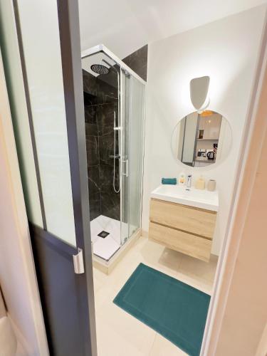une salle de bain avec une douche, un lavabo et un miroir dans l'établissement Joli Studio climatisé au calme, à Nice