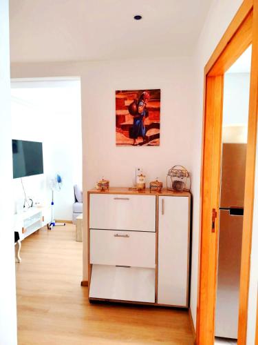 a room with a white dresser and a tv at appartement 2 chambres cosy luxe in Sale