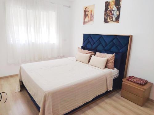 a bedroom with a large bed with a blue headboard at appartement 2 chambres cosy luxe in Sale