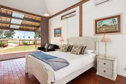 ein Schlafzimmer mit einem weißen Bett und einem Fenster in der Unterkunft Owl Head Lodge in Gulgong