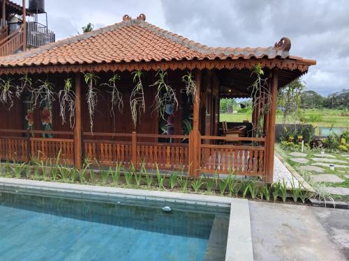 un gazebo in legno accanto alla piscina di Lotus cottage a Bedahulu