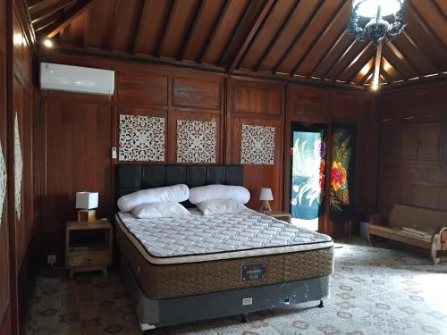 una camera da letto con un letto in una stanza di legno di Lotus cottage a Bedahulu
