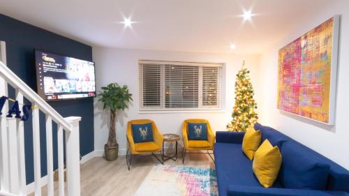 a living room with a christmas tree and two chairs at Rooftop Terrace with Harbour Views By Adliv in Ramsgate