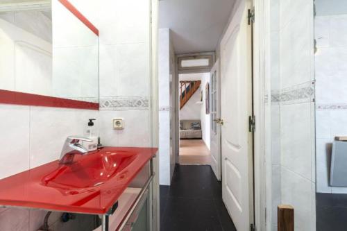 a red sink in a bathroom with a hallway at Atico duplex loft Lavapies in Madrid