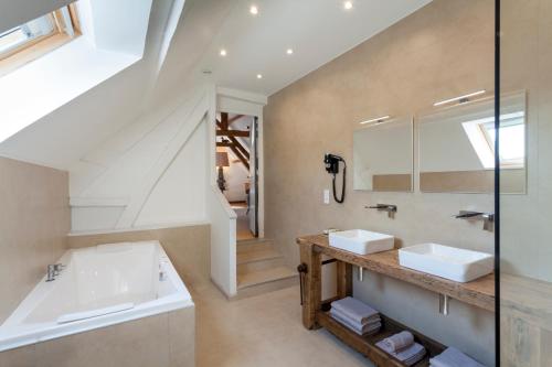 a bathroom with two sinks and a mirror at Logis La Ferme Du Vert in Wierre-Effroy