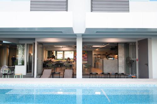 a swimming pool in front of a house with a restaurant at Mowa Bangkok in Bangkok