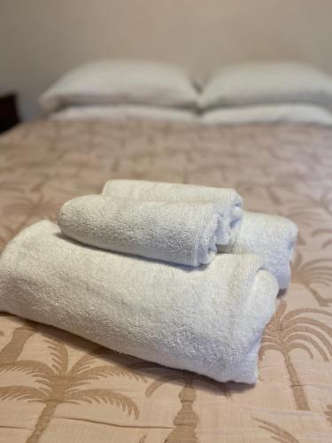 a pile of towels sitting on top of a bed at Netherby Guesthouse in Kempsey