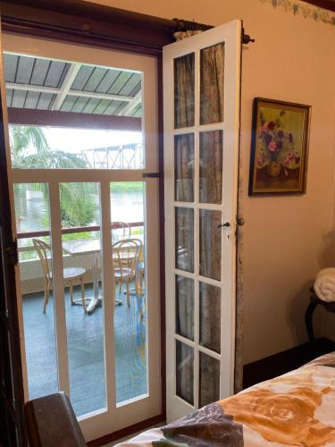 a bedroom with a door open to a patio with a table at Netherby Guesthouse in Kempsey