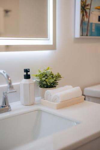 a bathroom sink with a bottle of soap and towels at Bishop Suites at Executive Centre in Honolulu