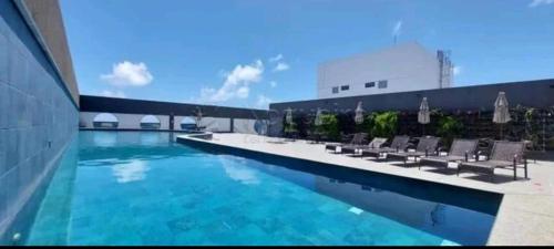 a swimming pool with chairs in a building at Flat beira mar Olinda Empresarial Jam in Olinda
