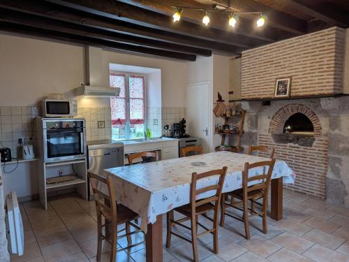 une cuisine avec une table et des chaises dans une pièce dans l'établissement Gîte tranquille avec jardin près de la Loire à vélo, labellisé Tourisme et Handicap - FR-1-590-21, à Cravant