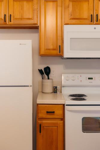 a kitchen with a white refrigerator and wooden cabinets at Bishop Suites at Executive Centre in Honolulu