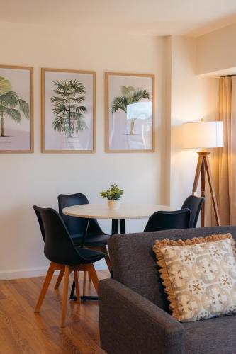 a living room with a couch and a table with chairs at Bishop Suites at Executive Centre in Honolulu