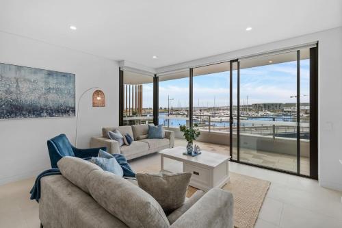 a living room with couches and a view of a harbor at Sailview Escape - A Tranquil Marina Hideaway in Shellharbour