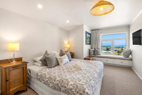 ein Schlafzimmer mit großem Bett und Fenster in der Unterkunft VIEWS, LOCATION plus SPA in Raglan