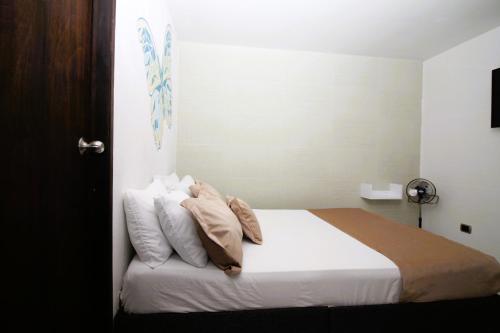 a bedroom with a bed with white sheets and pillows at DAM Hotel Pereira in Pereira