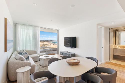 a living room with a table and chairs at Oceanview 2BR 2BA in The Miles Residences Kirra in Gold Coast