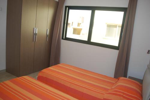 a bedroom with a bed and a window at Surf House Cabo Verde in Santa Maria