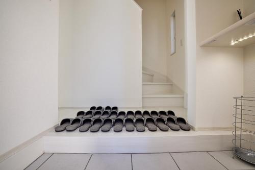 a white room with a stairway with a black chair at MIYA HOUSE Funatsu C in Fujikawaguchiko