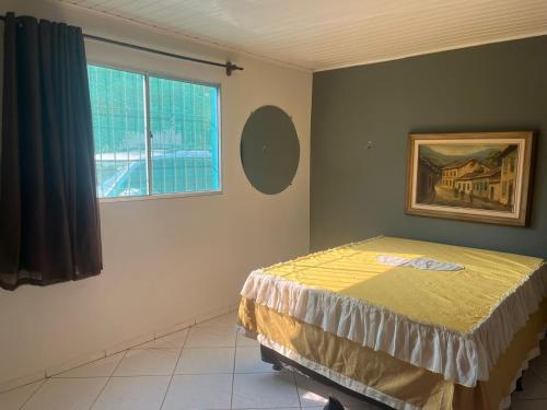 シャパダ・ドス・ギマランイスにあるCasa Tranquila e Familiar Para Temporada!のベッドと窓のある寝室