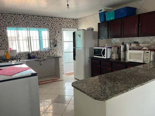 シャパダ・ドス・ギマランイスにあるCasa Tranquila e Familiar Para Temporada!のキッチン(冷蔵庫、カウンタートップ付)