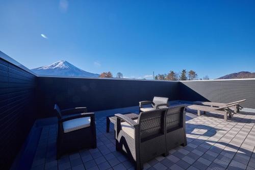 a patio with two chairs and a table and a bench at MIYA HOUSE Funatsu A in Fujikawaguchiko