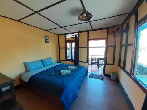a bedroom with a blue bed in a room at Sabai ça Baille Guesthouse in Pakse