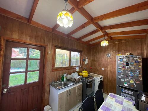 a kitchen with wooden walls and wooden ceiling at Casa Pingueral estufa - piscina - cercano a playa in Dichato