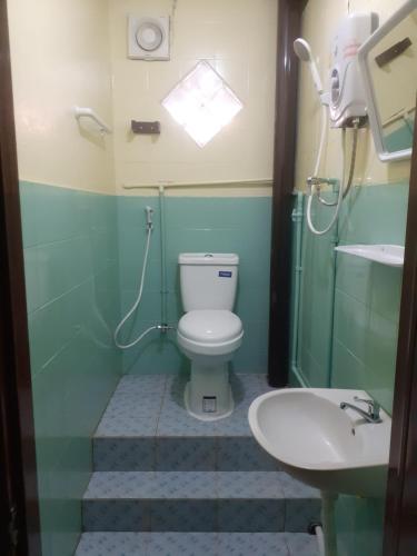 a bathroom with a toilet and a sink at Sabai ça Baille Guesthouse in Pakse