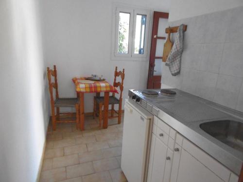 cocina con fregadero y mesa con sillas en Apartments Elli - Nikos en Ypsos