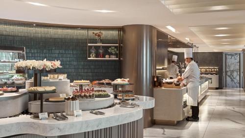 a kitchen with a chef preparing food in a restaurant at Hotel Royal-Nikko Taipei in Taipei